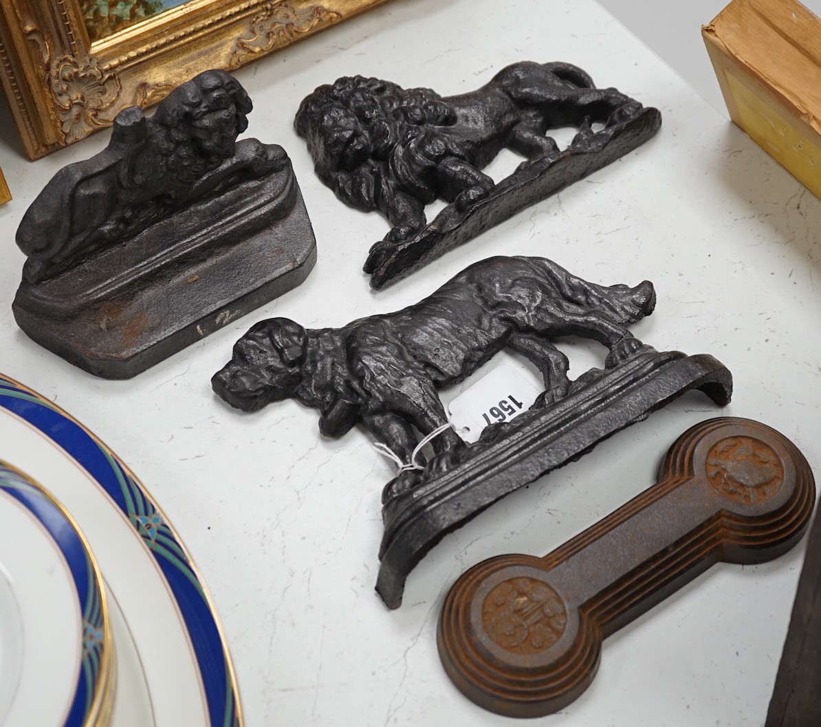 Two lion cast iron door stops, a St Bernard door stop and another, largest St Bernard 18cms high